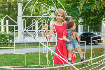 beautiful mother with her daughter in the park in summer