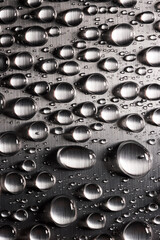 Abstract background with drops of water on metallic flat surface