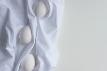 white chicken eggs on a white cloth.