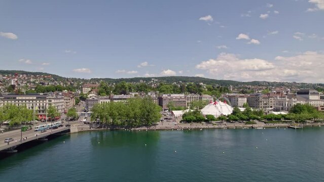 Aerial view over Lake Zürich seen from City of Zürich with white circus tent and bellevue square on a sunny and cloudy spring day. Movie shot May 30th, 2022, Zurich, Switzerland.