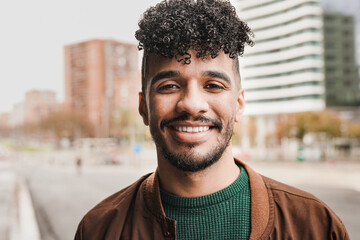 Young african man smiling on camera with city in background