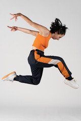 Ivry-Sur-Seine, France - 04 11 2022: studio photo. Studio shot of a young woman dancer with blue and orange hip hop dance clothes
