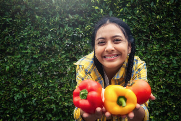 Happy teenager holding vegetable at fall day in organic farm. Harvesting on the farm.