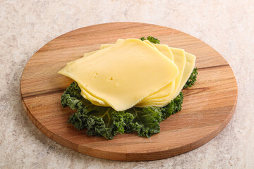 Sliced Gouda cheese over board