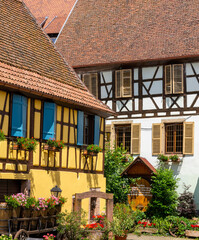 architectural detail of historic half-timbered houses with flowers and wooden carriage in front