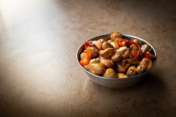Toasted corn nuts with chili peppers in a bowl on the table, appetizer snack