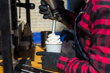 close up of hands serving cream to a cafe late in the street, coffee bike, food concept