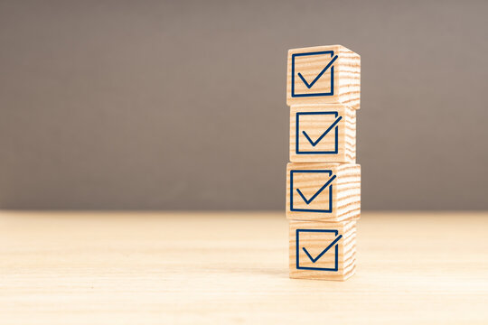 Checking or checklist concept. Wooden block with check icon stacked on wooden table. Copy space