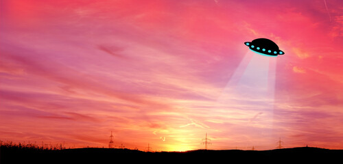 beautiful dramatic landscape, sky with airplane trail lines, power towers, field in evening in rays of sunset, concept of beauty of nature, modern energy, technology, black hills at bottom