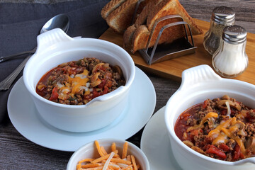 Bowls of chili, served with whole wheat toast, on a cool fall evening.