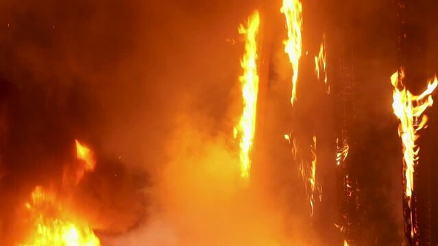 Three rescuers enter the burning building. View from the back. Emergency