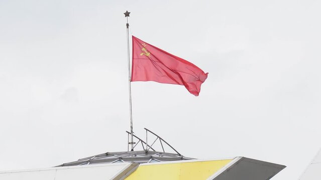 Historical concept. On the roof of the building, the flag of the Soviet Union flutters in the wind.