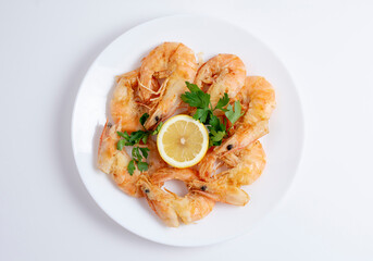 Fried shrimp or prawns in plate. Isolated on white background. Tasty seafood on plate