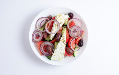 Greek salad with cheese and fresh vegetables isolated on white background. top view