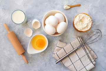 Homemade flour recipes (Eggs, flour, milk, sugar) on shiny gray concrete , view from above