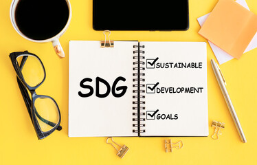 Sustainable Development Goals on notebook on yellow office workplace