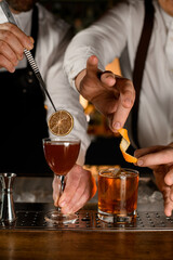 great view on glasses with drinks that bartenders decorate with orange zest and a dry slice of lemon