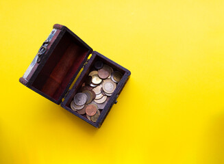 Wooden Box with coins. Beautiful yellow background. Business and box with coins concept. Copy space.