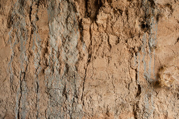 This very old textured clay wall is inside a dugout hillside in Wyoming. The clay is tan with green-blue tinges.
