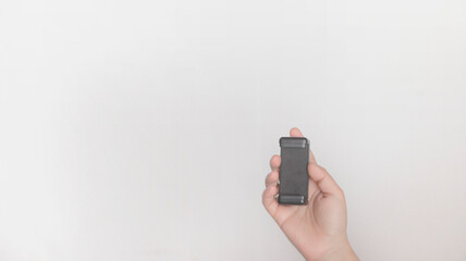 Hand holding a cell phone holder in black, on a white background.