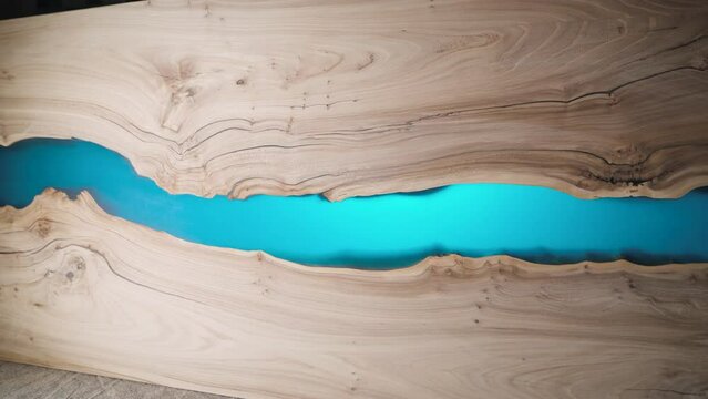 Beautiful surface of a wooden slab tabletop filled with epoxy resin.