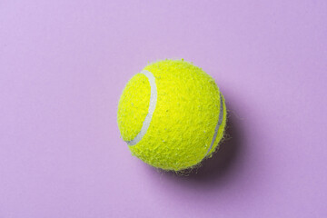 Yellow tennis ball on a purple table.