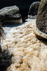 Sea salt foam by rocks and cliffs by the sea.