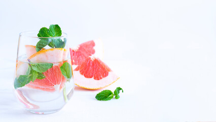 Grapefruit and mint drink on a light background. Image with selective focus