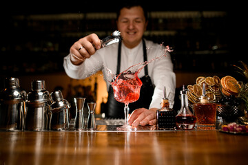 beautiful view on bar counter with a variety of bar equipment and goblet with splashing drink