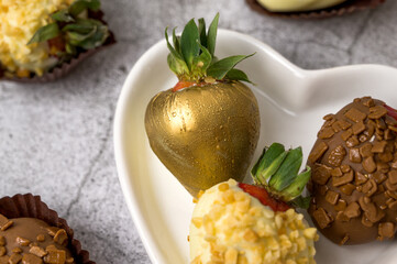 Fresh strawberries covered in chocolate painted gold.