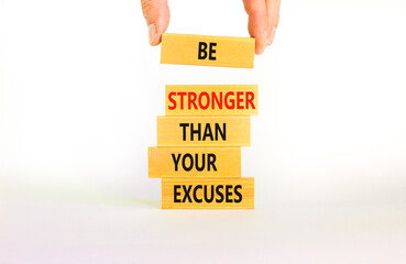 Be stronger symbol. Concept words Be stronger than your excuses on wooden blocks on a beautiful white table white background. Businessman hand. Business motivational and be stronger concept.