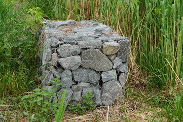 stones in a metal grid near the river