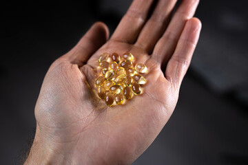 Fototapeta premium vitamin d medicinal fish oil capsules in the palm of your hand.