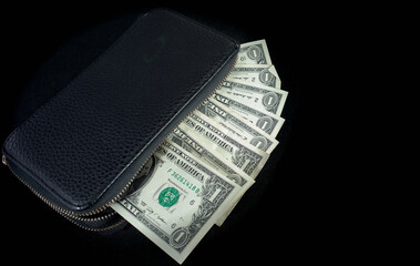 American dollars in a black wallet on a black background