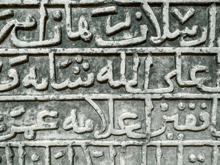 stone texture. letters are carved on a heavy, sandy board. ancient font, large, tall words are...