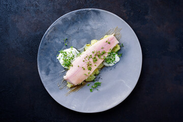 Modern style traditional smoked rainbow trout with boiled potato salad and mayonnaise served as top...