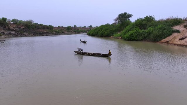 Description:  Aerial view of a canoe navigating the brown, polluted waters of the Oti River in Ghana, West Africa, affected by illegal mining. T