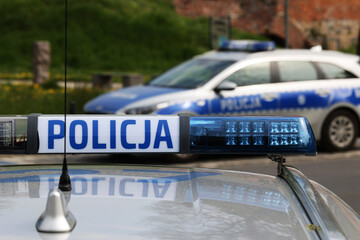 Radiowóz polskiej policji w mieście podczas patrolu.  - obrazy, fototapety, plakaty