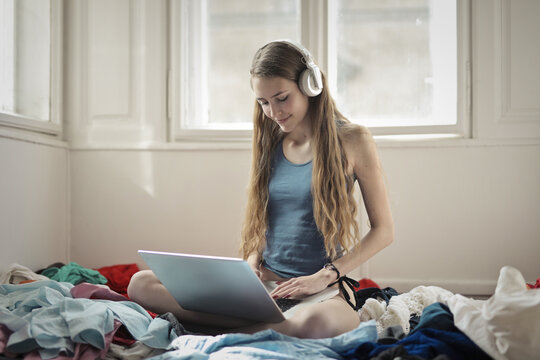 young woman uses a computer in her bedroom
