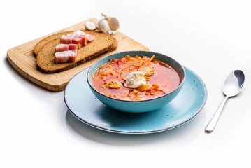 Ukrainian traditional cuisine. Red borscht with chicken in a blue plate. Isolate on white background