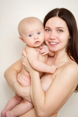 beautiful and gentle naked mom and baby against the wall