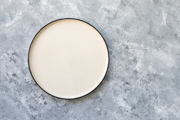 Empty white plate on gray concrete background. Top view, with copy space - obrazy, fototapety, plakaty