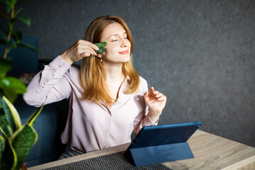 middle-aged woman doing facial massage with a gouache scraper caring for the body