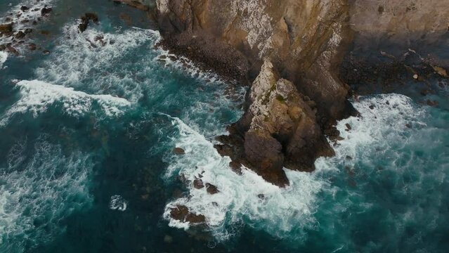 Waves crashing on rocks on beach Portugal Algarve Stunning Slow Motion Drone Aerial View blue ocean Atlantic