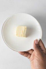 Butter on a white plate, knob of butter
