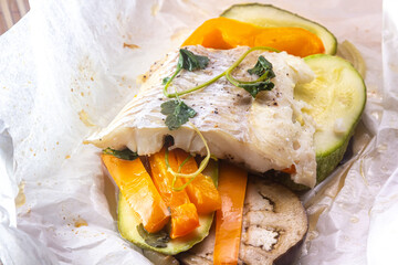 White fish fillet with vegetables in rustic style. Healthy eating: cooked fish fillet with vegetables garnish. Diet food with white fish and vegetables. Steam vegetables with roasted zander fillet