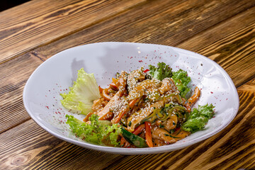 Chicken stir fry with vegetables soy sause and sesame in the wok. Traditional asian food. Top view wiht copy space on stone table