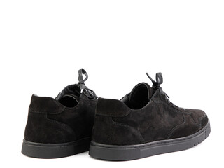 Black suede classic sneakers with laces. Casual men's style. Black rubber soles. Isolated close-up on white background. Back side view.