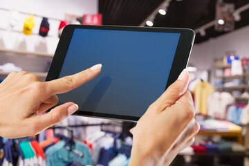 Smart store management systems concept. Manager using digital tablet on blurred store as background