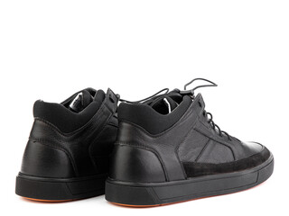 Black leather classic sneakers with laces. Casual men's style. Black rubber soles. Isolated close-up on white background. Back side view.